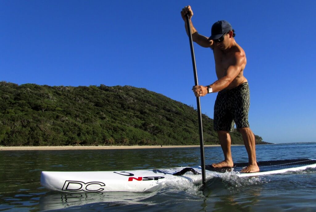 Person paddling on a touring/racing stand up paddle board