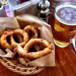Basket of onino rings and a draft beer