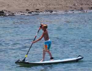 Kid paddle boarding in Kona, Hawaii