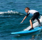 kid surfing a wave in kona hawaii