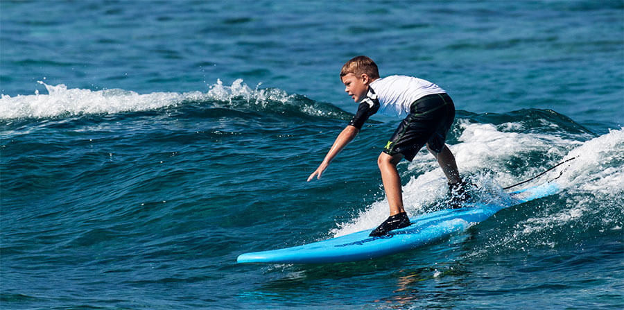 kid surfing a wave in kona hawaii