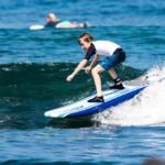 Kid surfing a wave in Kona, Hawaii