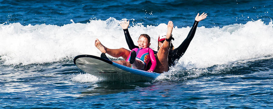 kid falling on wave while surfing in kona, hawaii