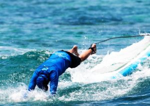 surfer wiping out head first on a surfboard