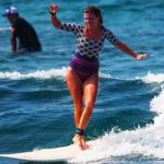 Woman surfer cross steping on a longboard in Hawaii